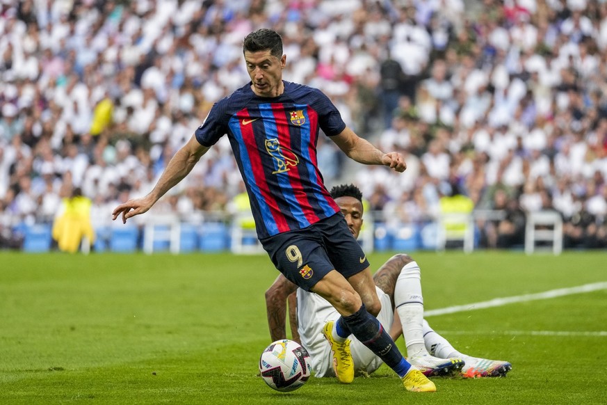 Barcelona&#039;s Robert Lewandowski, foreground, duels for the ball with Real Madrid&#039;s Eder Militao during La Liga soccer match between Real Madrid and FC Barcelona in Madrid, Spain, Sunday, Oct. ...