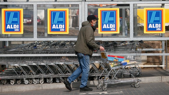 RUESSELSHEIM, GERMANY - APRIL 8: A shopper pushs a shopping cart outside an Aldi store on April 8, 2013 in Ruesselsheim near Frankfurt, Germany. Aldi, which today is among the world’s most successful  ...