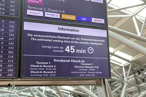 17.05.2023, Hamburg: Mehr als 45 Minuten Wartezeit vor der Sicherheitskontrolle wird auf einer Anzeigentafel am Flughafen Hamburg angezeigt. Die Wartezeit betrug am Mittwochmorgen bis zu 45 Minuten. P ...
