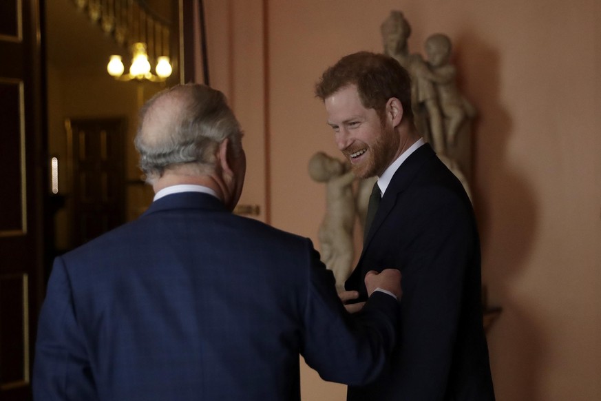 Britain's Prince Harry is gently greeted by his father Prince Charles upon their separate arrival to attend a coral reef health and resilience meeting with speeches and a reception with delegates at F ...