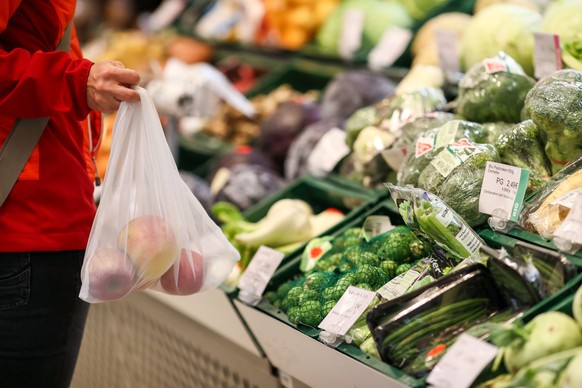 ARCHIV - 15.11.2019, Sachsen, Leipzig: Eine Kundin steht mit einem Mehrweg-Einkaufsnetz in der Obst- und Gemüseabteilung in einem Supermarkt. Angesichts der Preisexplosion in Supermärkten und bei Disc ...