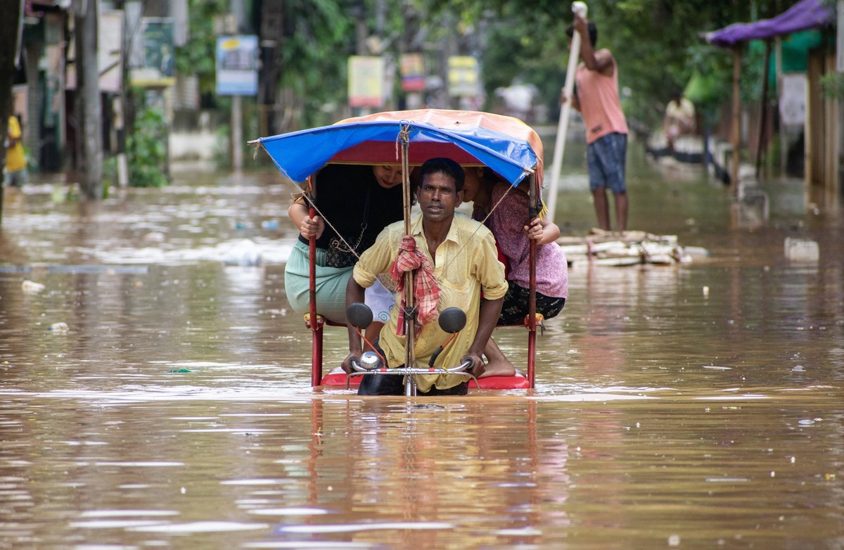 October 6, 2023: Guwahati, Assam, India, Commuters on a rickshaw to cross a waterlogged road after heavy rainfall in Guwahati. Severe water logging witnessed in Guwahati city following heavy rains, as ...
