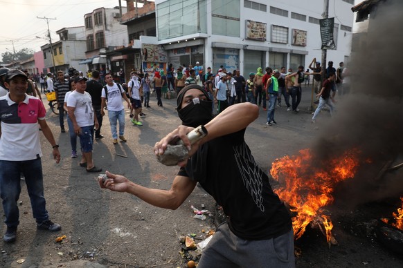 A demonstrator throws rocks during clashes with the Bolivarian National Guard in Urena, Venezuela, near the border with Colombia, Saturday, Feb. 23, 2019. Venezuela&#039;s National Guard fired tear ga ...