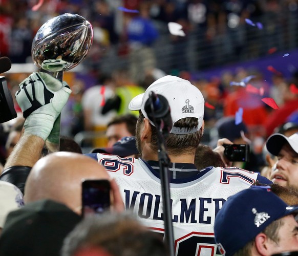 epa04600639 New England Patriots tackle Sebastian Vollmer of Germany holds the Vince Lombardi Trophy after the New England Patriots defeated the Seattle Seahawks to win Super Bowl XLIX at the Univeris ...