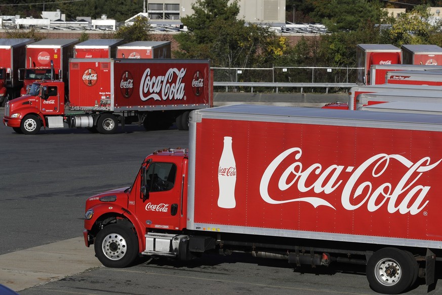 ARCHIV - 14.10.2019, USA, Needham: LKW mit dem Coca-Cola-Logo stehen auf einem Parkplatz in einer Abf