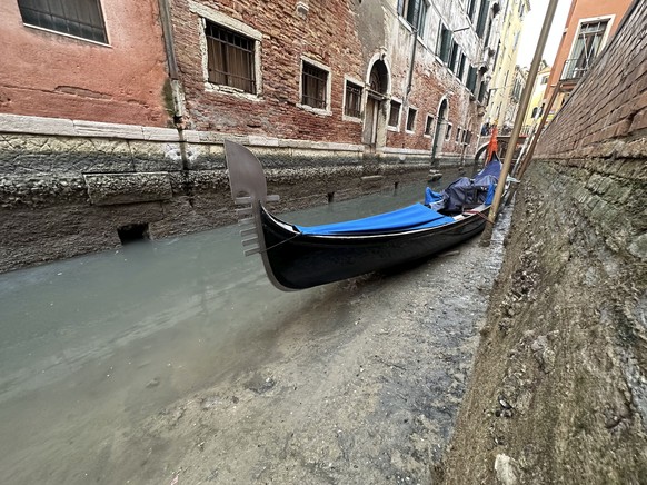 20.02.2023, Italien, Venedig: Eine Gondel liegt bei Ebbe an einem Kanal. Die Dürre im Norden Italiens nimmt nach Einschätzung von Umweltschützern immer alarmierendere Ausmaße an. Foto: Luigi Costantin ...