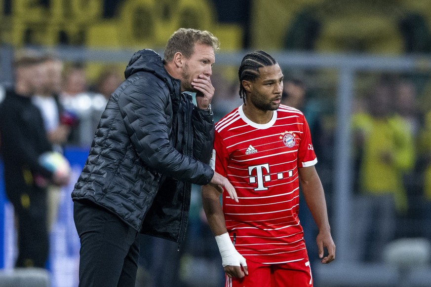 ARCHIV - 08.10.2022, Nordrhein-Westfalen, Dortmund: Fußball: Bundesliga, Borussia Dortmund - Bayern München, 9. Spieltag, Signal Iduna Park: Münchens Trainer Julian Nagelsmann (l) gibt Münchens Serge  ...