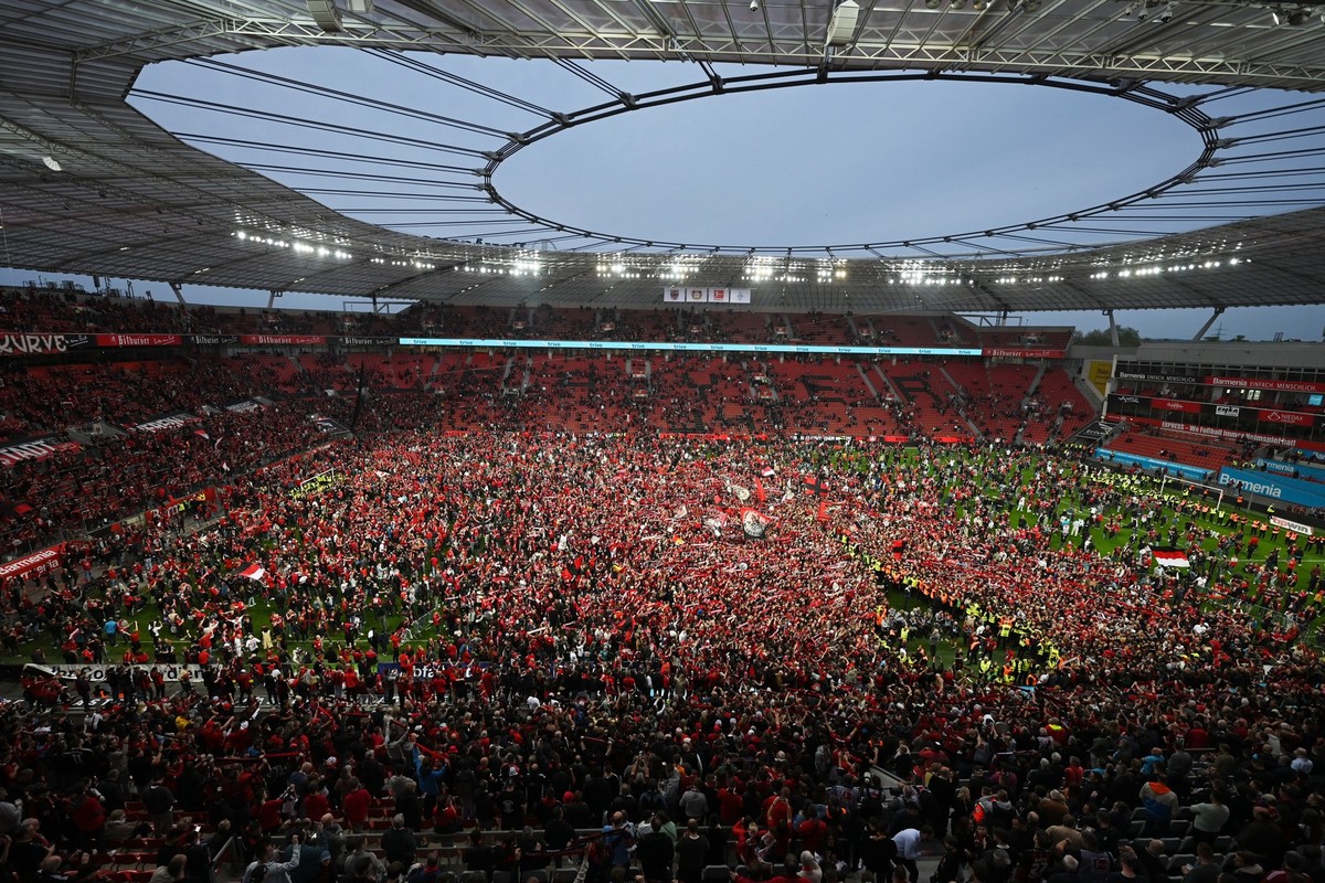 14.04.2024, Nordrhein-Westfalen, Leverkusen: Fu�ball: Bundesliga, Bayer 04 Leverkusen - SV Werder Bremen, 29. Spieltag, BayArena. Leverkusens Fans bejubeln auf dem Rasen den Gewinn der Deutschen Meist ...