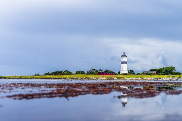 Sweden, Halland, Falkenberg, Cloudy sky over lighthouse in Morups Tange reserve, STSF03253