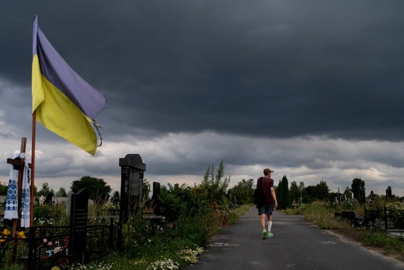 Valeryi Mahyd, 59, visits a cemetery where several of his friends were buried after they were killed by Russian troops in Bucha, Ukraine, Friday, July 7, 2023. Bucha was occupied by the Russian forces ...