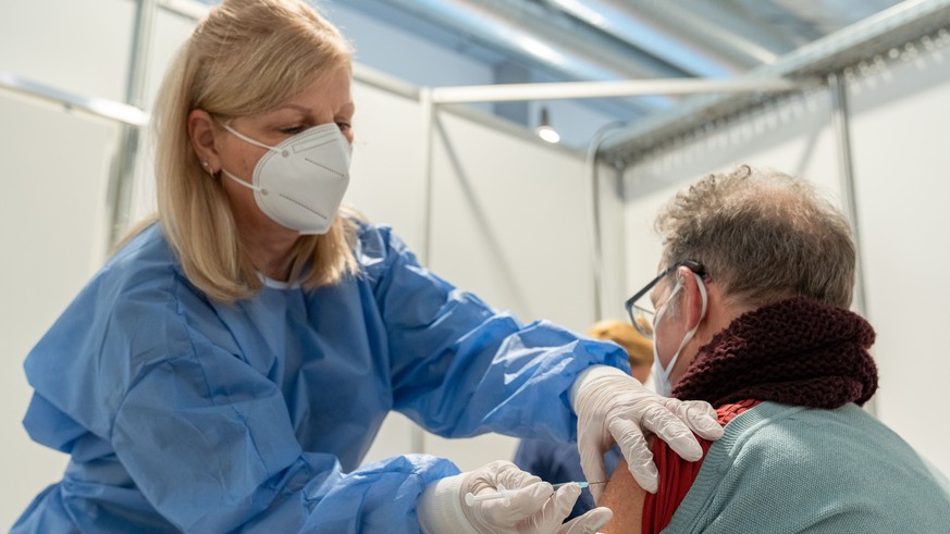 17.12.2020, Bayern, Bamberg: Eine medizinische Fachangestellte setzt bei einem Probedurchlauf im Impfzentrum Bamberg bei einem Mann die Kan