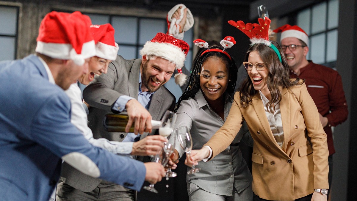 Cheerful entrepreneurs drinking champagne on New Year&#039;s party in the office. Weihnachtsfeier Büro