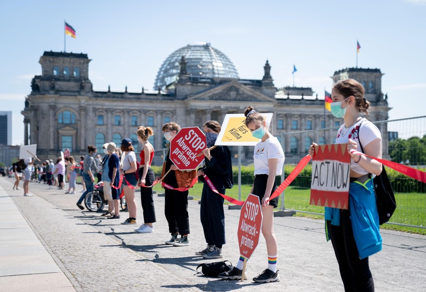 dpatopbilder - 02.06.2020, Berlin: Aktivisten demonstrieren mit einer Menschenkette und Plakaten vor dem Bundeskanzleramt gegen eine m
