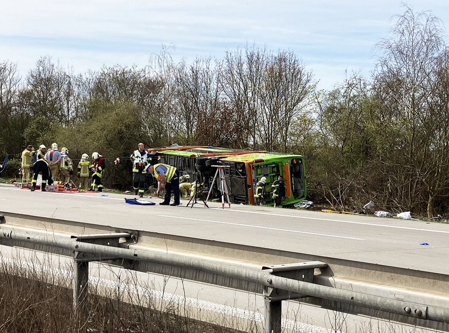 27.03.2024, Sachsen, Schkeuditz: Ein Reisebus liegt zur Seite gekippt an der Unfallstelle auf der A9. Bei einem Unfall mit einem Reisebus auf der A9 nahe Leipzig sind mindestens fünf Menschen ums Lebe ...