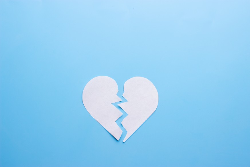 Broken heart on blue background. breakup concept