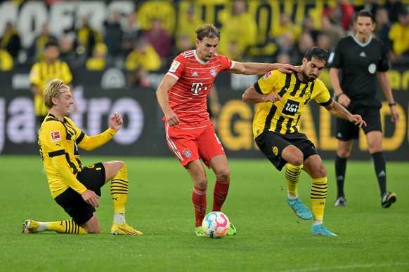 08.10.2022, Nordrhein-Westfalen, Dortmund: Fu�ball: Bundesliga, Borussia Dortmund - FC Bayern M�nchen, 9. Spieltag, Signal Iduna Park. M�nchens Leon Goretzka (M) k�mpft mit Dortmunds Julian Brandt (l) ...