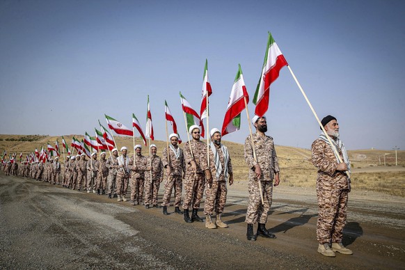 In this photo provided by Revolutionary Guard&#039;s ground force on Monday, Oct. 17, 2022, clerics hold Iranian flags while attending a maneuver in northwestern Iran. (Iranian Revolutionary Guard&#03 ...
