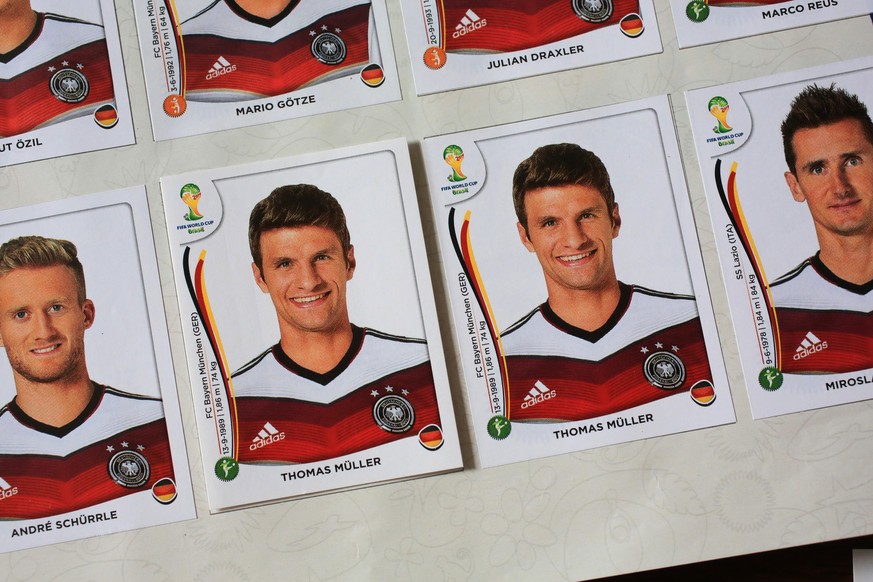Fußball-Sammelbilder gibt es zu jedem großen Turnier. Hier kleben die Ex-Nationalspieler Schürrle, Müller und Klose in einem Album zur WM 2014.