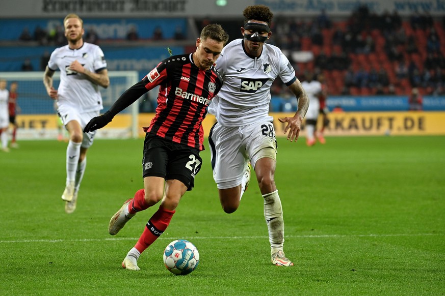 211216 -- LEVERKUSEN, Dec. 16, 2021 -- Florian Wirtz L of Leverkusen vies with Christopher Richards of Hoffenheim during the German first division Bundesliga football match between Bayer 04 Leverkusen ...