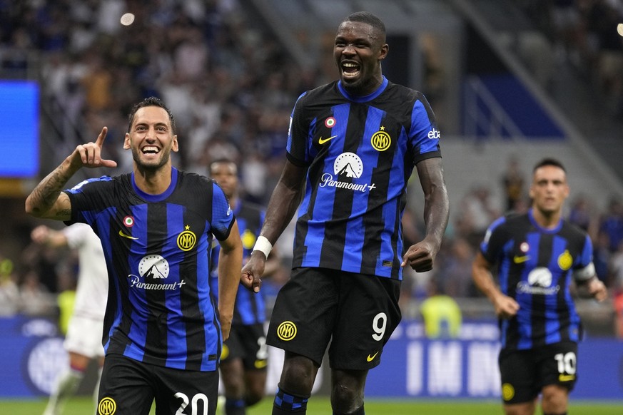 Inter Milan&#039;s Hakan Calhanoglu, left, celebrates with Inter Milan&#039;s Marcus Thuram after scoring his sides third goal during the Serie A soccer match between Inter Milan and Fiorentina at the ...