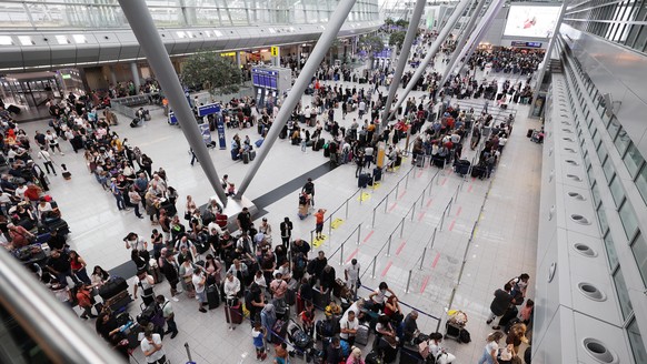 Lange Warteschlangen im Düsseldorfer Flughafen. Menschen stehen der Warteschlange, um das Gepäck abzugeben . (zu dpa: «Koffer-Chaos am Düsseldorfer Flughafen»)