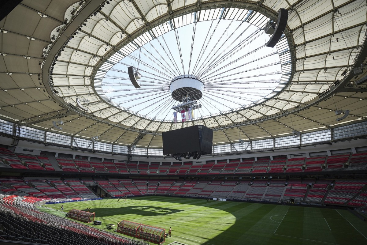 Stadium staff prepare temporary grass that was laid on top of artificial turf at BC Place stadium for an international friendly soccer match between MLS&#039; Vancouver Whitecaps and League One&#039;s ...