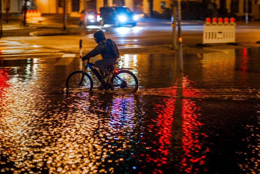 dpatopbilder - 20.10.2023, Mecklenburg-Vorpommern, Wismar: Ein Radfahrer fährt durch das Hochwasser am Stadthafen. Wegen einer erwarteten Sturmflut an der Ostseeküste sind Uferbereiche in der Nähe des ...