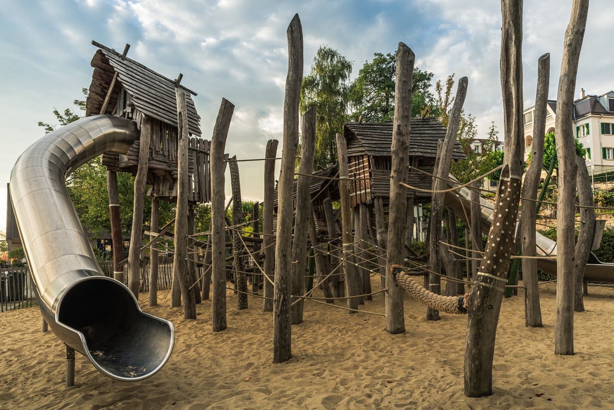 Empty children outdoor playground with wooden huts, climbing equipment and slide, Bodman-Ludwigshafen, Baden-Wuerttemberg, Germany