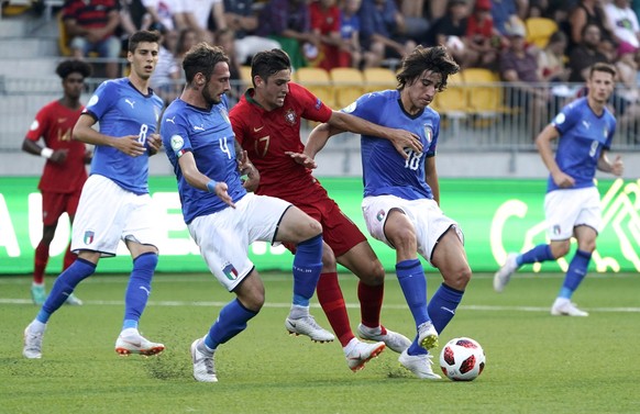 Italy's Gianmaria Zanandrea and Sandro Tonali, right, challenge Portugal's Joao Filipe for the ball during the European Under-19 Championship soccer final match between Italy and Portugal in Seinajoki ...