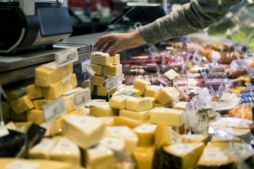 close up person hand buying cheese in the store