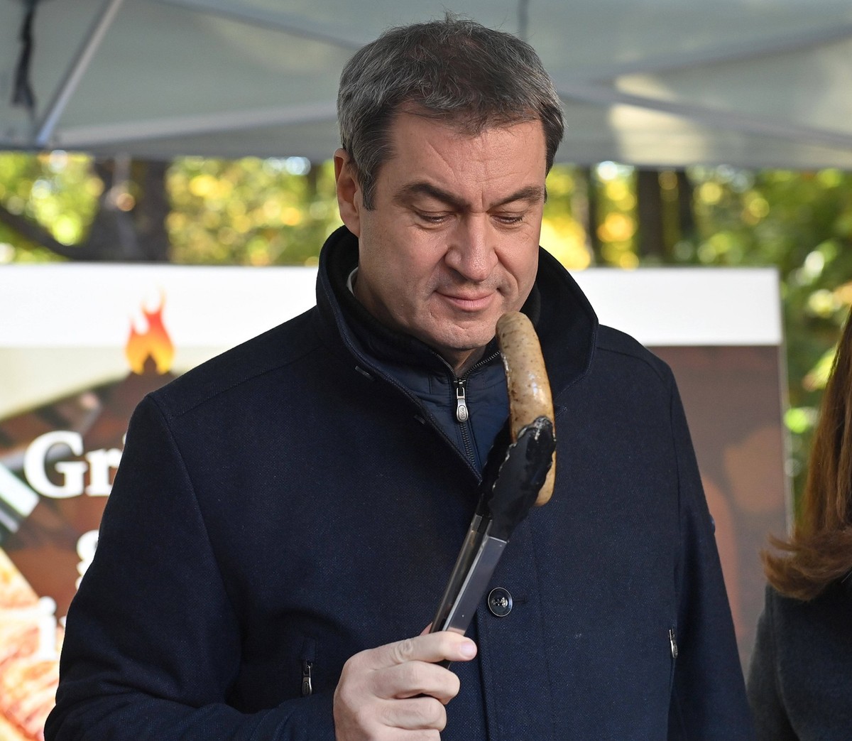 Grillmeister Markus SOEDER am Grill,haelt eine Bratwurst vor sein Gesicht. Markus SOEDER Ministerpraesident Bayern und CSU Vorsitzender ,Landwirtschaftsministerin Michaela Kaniber und der Praesident d ...