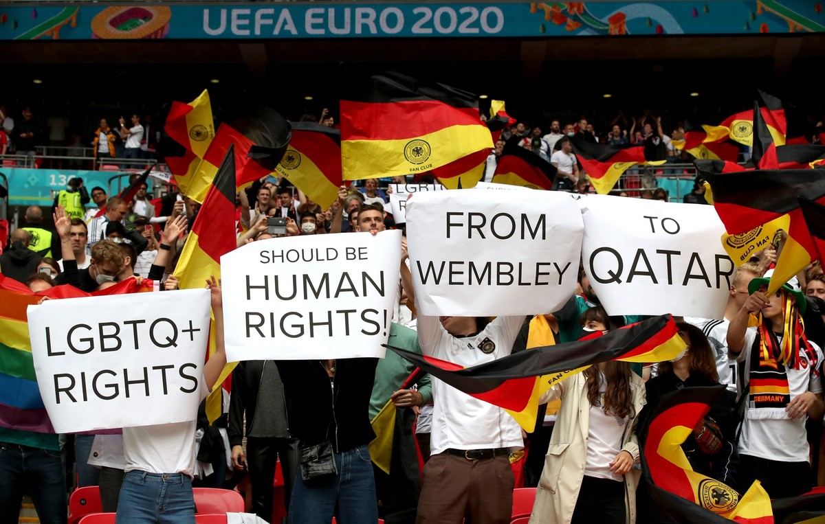 ARCHIV - 29.06.2021, Gro�britannien, London: Fu�ball: EM, England - Deutschland, Finalrunde, Achtelfinale im Wembley Stadion. Fans von Deutschland halten Plakate mit der Aufschrift &quot;LGBTQ+ RIGHTS ...