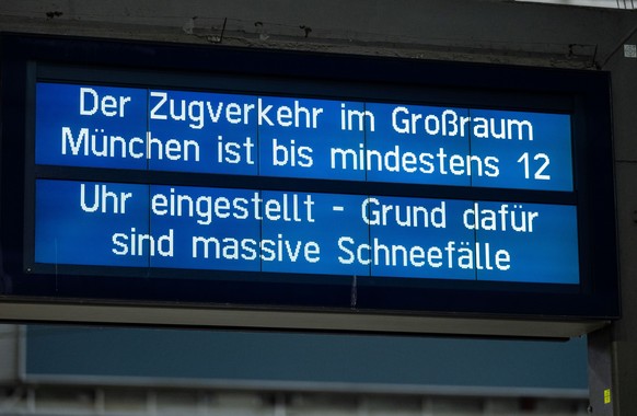 02.12.2023, Bayern, München: Ein Schild weist am Hauptbahnhof auf den eingestellten Zugverkehr im Großraum München hin. Der Zugverkehr von und zum Hauptbahnhof wurde vorübergehend eingestellt. Schnee  ...
