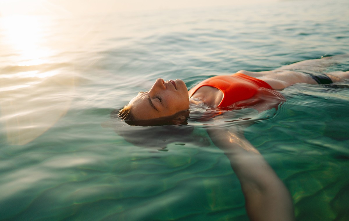 Photo of a mid adult woman swimming in the calm ocean.