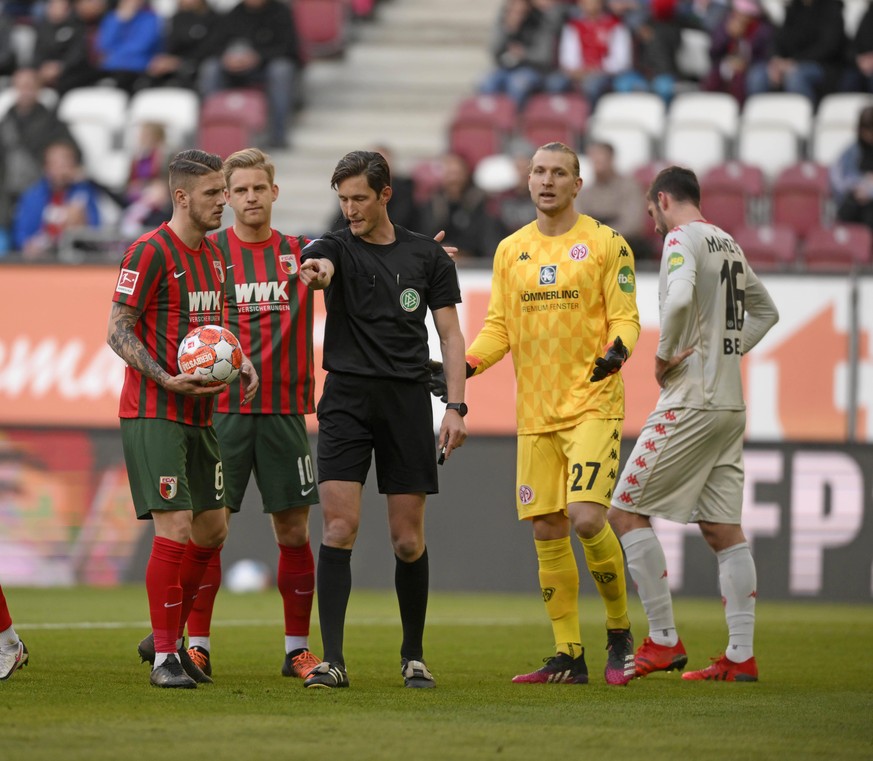 Der Moment, in dem Schiedsrichter Matthias Jöllenbeck (M.) beim Spiel zwischen Augsburg und Mainz auf Elfmeter entscheidet.