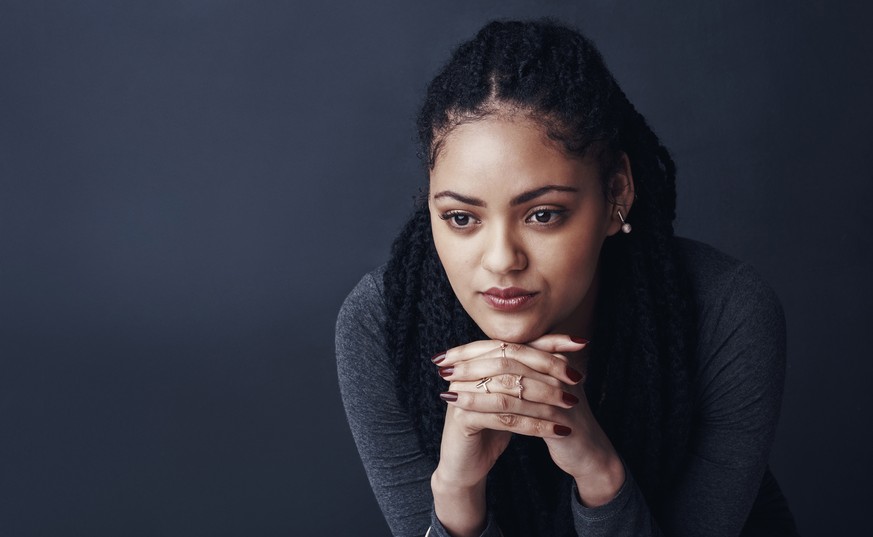 Studio shot of a young woman posing against a gray background