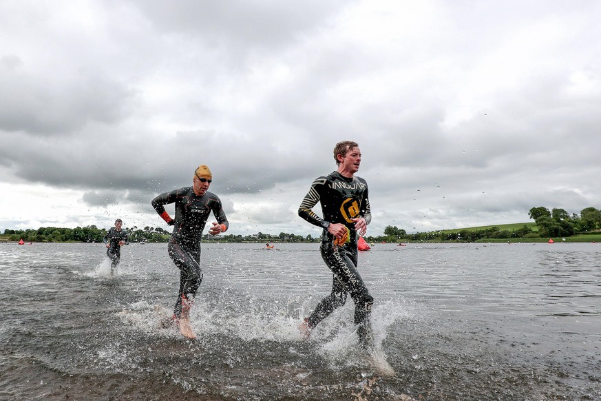 Triathleten verlassen das Wasser nach dem Schwimmen