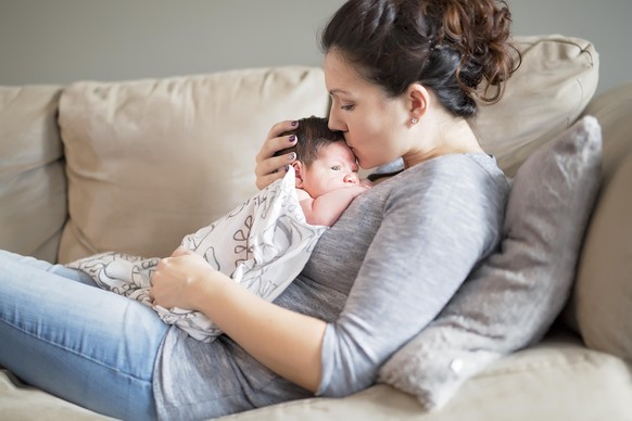 A Happy mother holding adorable child baby on the living room