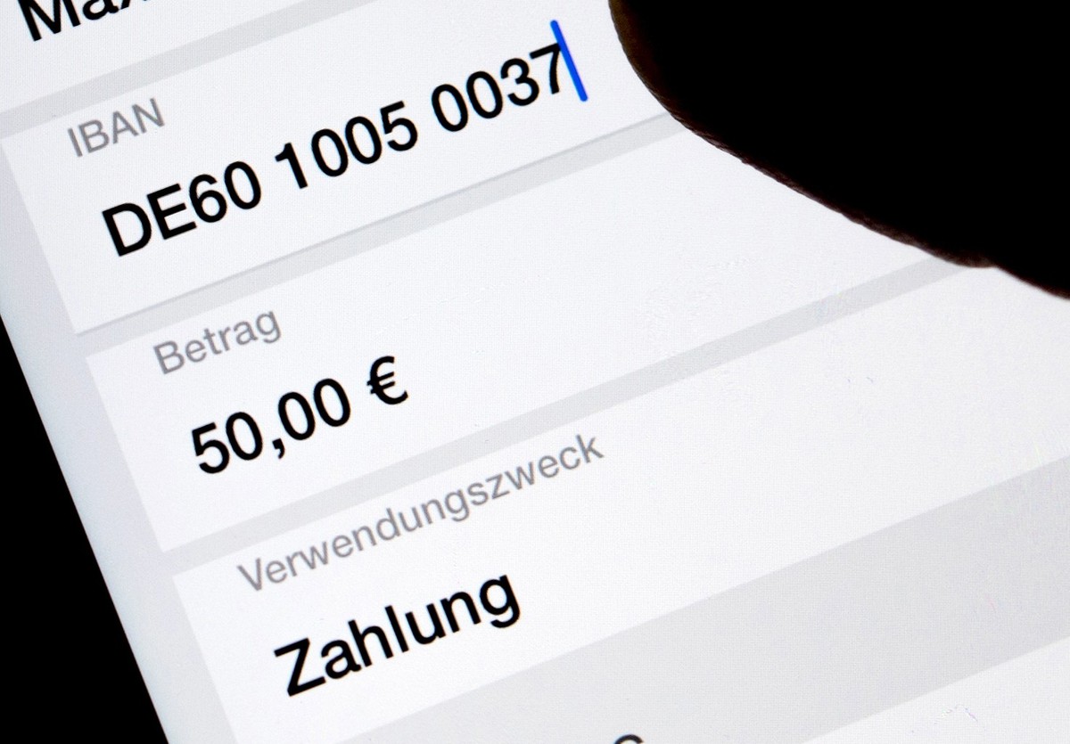 ARCHIV - 03.12.2018, Sachsen, Dresden: ILLUSTRATION - Eine Frau nutzt auf ihrem Smartphone eine App, um im Online-Banking eine SEPA-Überweisung zu veranlassen (gestellte Szene). Echtzeitüberweisungen  ...