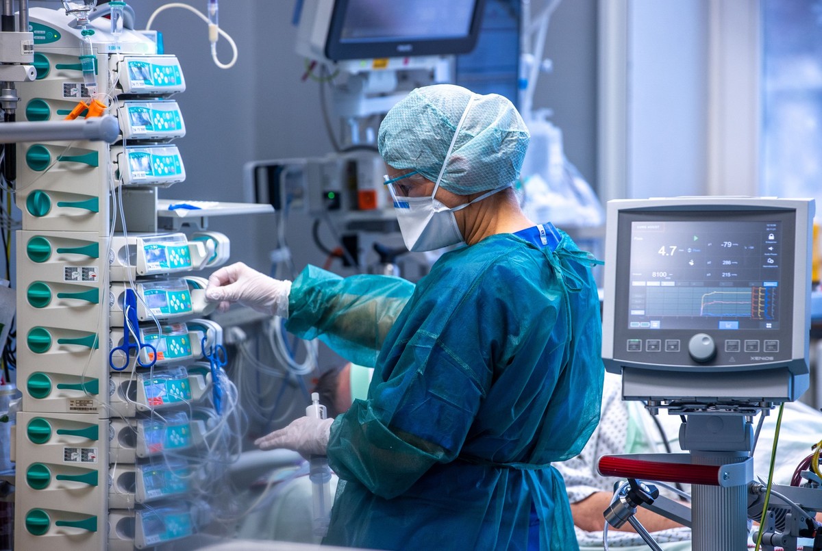 ARCHIV - 30.11.2021, Mecklenburg-Vorpommern, Rostock: Ärzte und Pflegekräfte betreuen Patienten in einem der Behandlungszimmer der Intensivstation in der Universitätsmedizin Rostock im Jahr 2021. Die ...