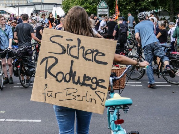 BERLIN, GERMANY - JULY 2: A demonstrator with a banner reading &quot;Secure bike-lanes for Berlin&quot; as activists protesting against the city government&#039;s halt on new bicycle lanes demonstrate ...