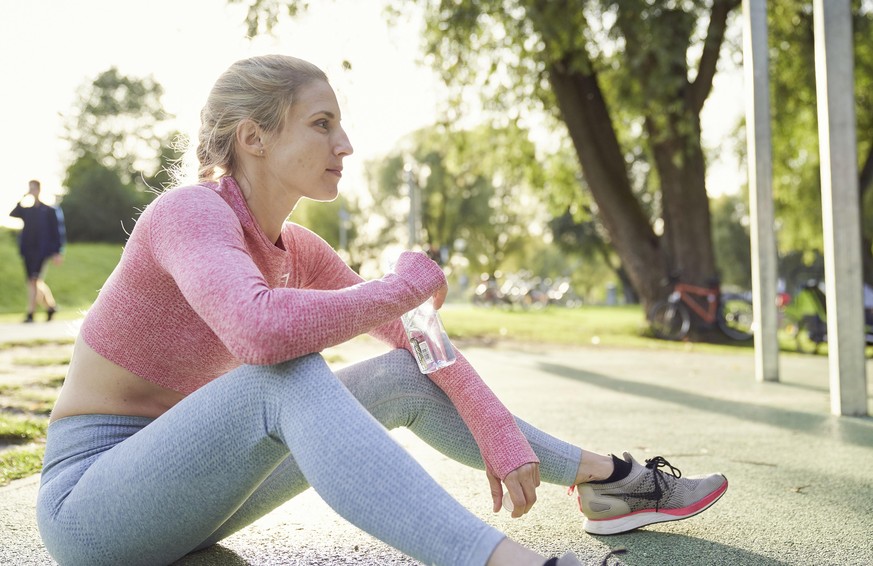 Junge Frau trinkt Wasser, Outdoor-Sport, Olympiapark, München, Deutschland, Europa || Modellfreigabe vorhanden