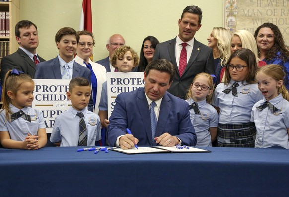 FILE - Florida Gov. Ron DeSantis signs the Parental Rights in Education bill at Classical Preparatory school, on March 28, 2022, in Shady Hills, Fla. The Walt Disney Company announced late Sunday, Nov ...