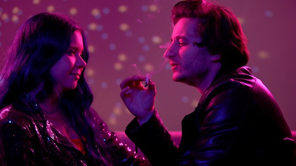 Relaxed couple smoking weed and flirting at night club party, carefree life