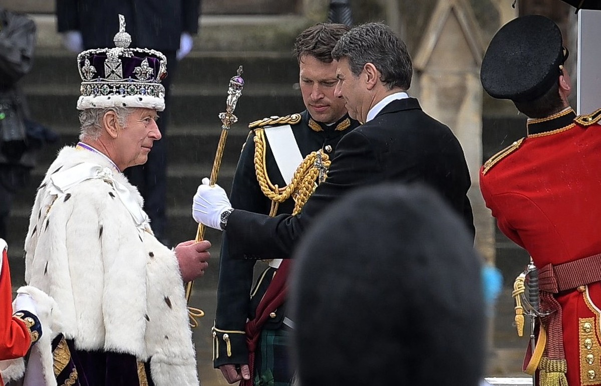 ARCHIV - 06.05.2023, Großbritannien, London: König Charles III. kommt nach der Krönung aus der Westminster Abbey und überreicht ein Zepter. Neben ihm steht Major Jonathan &quot;Johnny&quot; Thompson ( ...