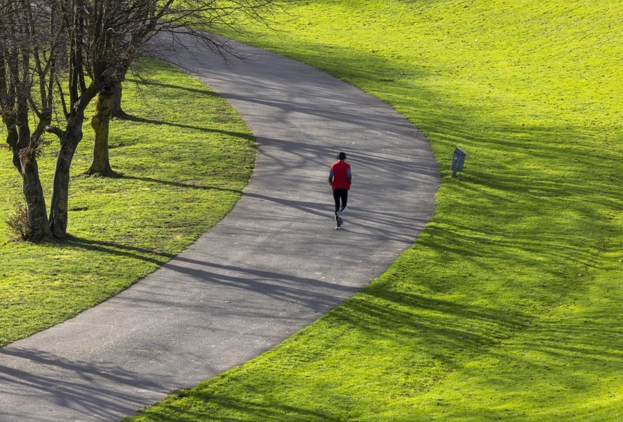 25.02.2024, Nordrhein-Westfalen, Bonn: Ein Jogger läuft am Morgen bei Sonnenschein in der Rheinau. Das Wetter in Nordrhein-Westfalen zeigt sich am letzten Februar-Wochenende wechselhaft und als Mix au ...