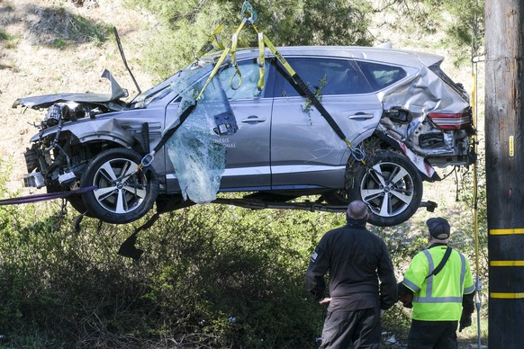 A crane is used to lift a vehicle following a rollover accident involving golfer Tiger Woods, Tuesday, Feb. 23, 2021, in the Rancho Palos Verdes suburb of Los Angeles. Woods suffered leg injuries in t ...