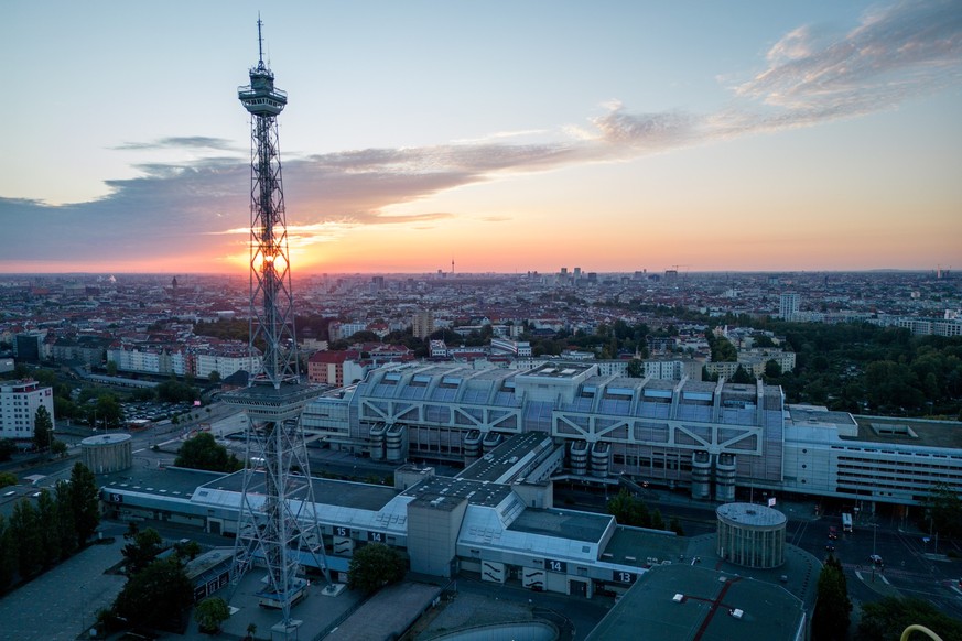 ARCHIV - 08.08.2022, Berlin: Blick auf Berlin im Sonnenaufgang mit dem Funkturm und dem ehemaligen Internationalen Congress Centrum (ICC) im Vordergrund. Auf den Dächern der Berliner Messe entsteht in ...