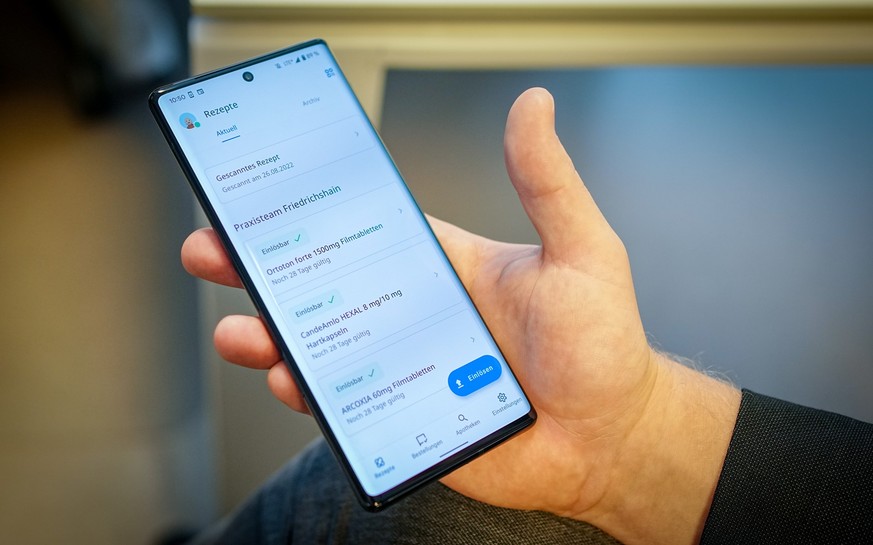 26.08.2022, Berlin: Ein Patient zeigt in einer Friedrichshainer Arztpraxis ein fiktives E-Rezept. Der Gesundheitsminister informierte sich hier zum E-Rezept. Foto: Kay Nietfeld/dpa +++ dpa-Bildfunk ++ ...