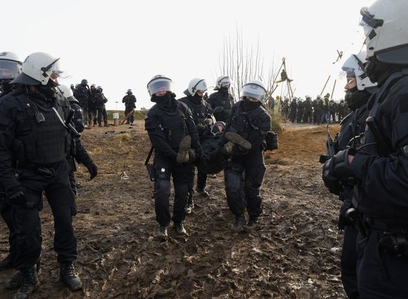 Police officers carry away a demonstrator to clear a road at the village Luetzerath near Erkelenz, Germany, Tuesday, Jan. 10, 2023. A court in Germany has rejected a last-ditch attempt by climate acti ...